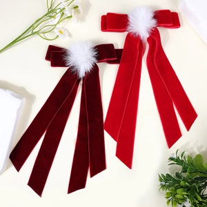 Red velvet ribbon hair clip with white pom-pom detail for women in retro style