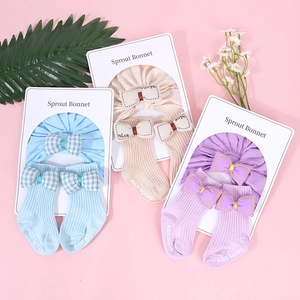 Detalle del conjunto de gorro turbante y calcetines para bebé con lazos de colores