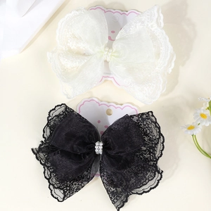 Detail of vintage lace bow hair clips with faux pearl accents and organza layers