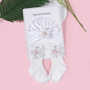 Detail von Baby-Set aus weißer Baumwolle mit Mütze und Socken mit Paillettenblumen