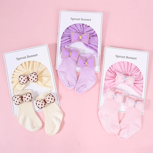 Detalle del conjunto de diadema y calcetines para bebé con lazos y textura de punto fino