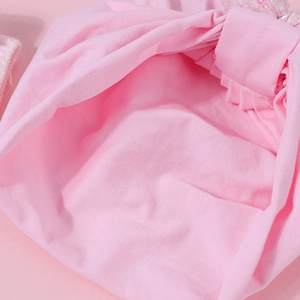 Dettaglio ravvicinato del turbante in cotone rosa per neonati con paillettes e cuciture