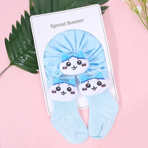 Detail of light blue cotton baby bonnet and matching socks with cute cat decor