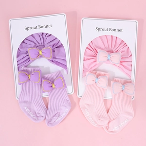 Detalle del conjunto de turbante y calcetines para recién nacido con lazos