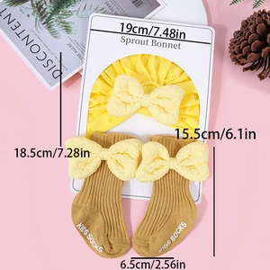 Detail view of cotton baby bonnet and socks set with large yellow bows and size guide