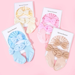 Detailed set of cotton baby bonnets and socks with bows in yellow, pink, blue, and beige