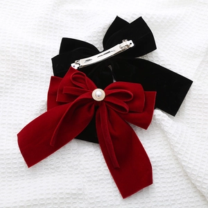 Close-up of velvet bow hair clips with pearl rhinestones and silver metal spring grip