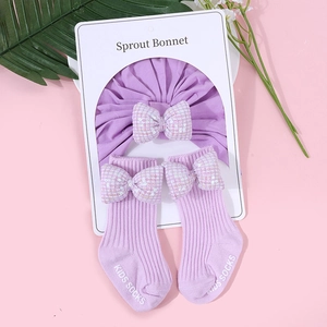Dettaglio del turbante e calzini in cotone lavanda per neonati con fiocchi di paillettes