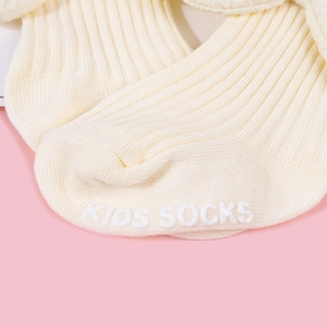 Detail of baby socks with white anti-slip rubber grip text on soft cotton ribbed fabric