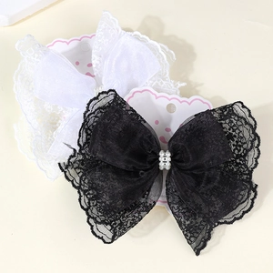 Close-up of lace ribbon bow hair clips with pearl beads for girls in black and white