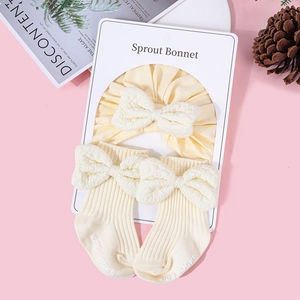 Detail of baby headband and socks set with textured bubble fabric bows in cream yellow