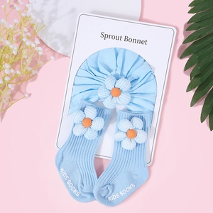 Vue détaillée du bandeau et des chaussettes bleu clair pour bébé avec fleurs à carreaux