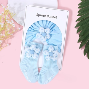 Détail du turban bleu clair pour bébé et chaussettes assorties avec fleurs à pois