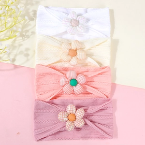 Vue détaillée de quatre bandeaux bébé élastiques avec fleurs en tissu et paillettes