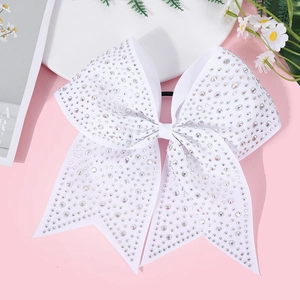 Detail shot of white ribbon bow hair tie with shiny rhinestones for girls' party hairstyles