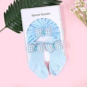 Detalle de set para bebé en azul cielo con gorro y calcetines con lazos de cuadros
