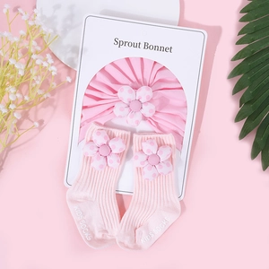 Détail du turban et chaussettes en coton rose pour bébé avec fleurs 3D à pois