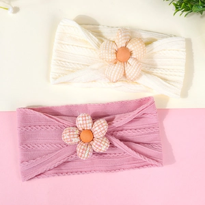 Détail du bandeau élastique pour bébé avec texture côtelée et fleur en tissu 3D
