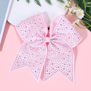 Macro detail of pink ribbon bow hair clip decorated with sparkling colorful rhinestones