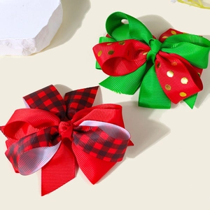 Detailed view of handmade Christmas hair bows with red ribbons and golden polka dots