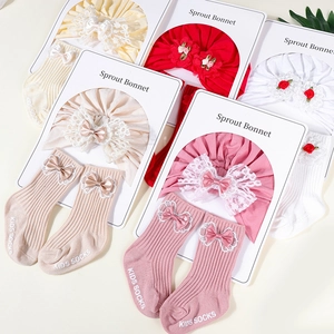 Detail of cotton baby bonnet and ribbed socks set with lace bows in assorted colors