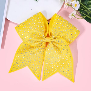 Detail of yellow bow hair clip with sparkling rhinestones for girls party style