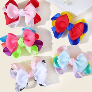 Close-up of layered grosgrain ribbon hair bows in vibrant colors and cow print patterns