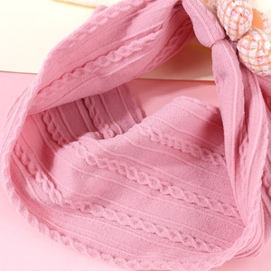 Détails de la texture du bandeau tricoté rose pour bébé avec fleur à paillettes