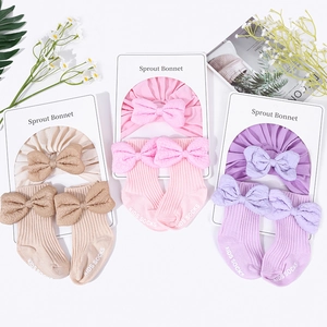 Cotton knit baby bonnet and socks set with large decorative bows in pastel colors