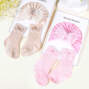 Infant cotton bonnet and matching socks set with delicate lace bow in pink and beige