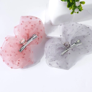 Detail of pink and purple mesh bow hair clips with rhinestone centers on white base