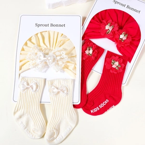 Detail view of cotton turban hat and matching rib-knit socks set with lace bow