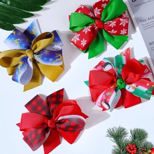 Detail view of multi-layered Christmas hair bows with reindeer and snowflake ribbon patterns