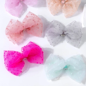 Close-up of colorful polka dot bow hair clips with crystal buckles in multiple pastel shades