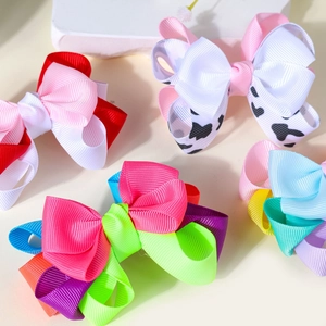 Detailed macro view of multi-layered ribbed grosgrain ribbon bow hair clips in assorted colors