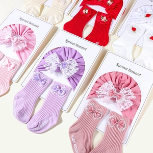 Flat lay of cotton infant headbands with lace bows and matching mid-calf socks set