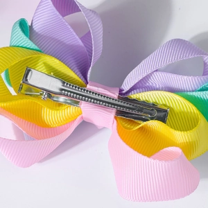 Detail of metal alligator clip on colorful layered grosgrain ribbon hair bow