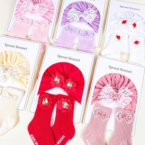 Detail view of cotton baby turban sets with large lace bows and matching ribbed socks