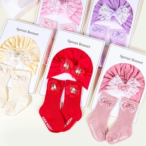 Detailed view of soft cotton baby turban hat and matching bow socks in various colors