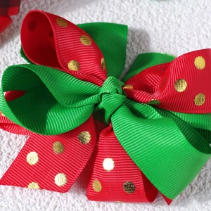 Detail of red and green Christmas bow hair clip with gold polka dots and ribbon texture