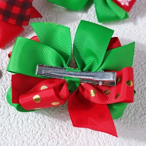 Detail showing red and green ribbon bow hair clip with silver metal crocodile clip