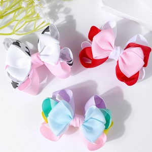 Detailed macro view of layered grosgrain ribbon bow clips with various colorful patterns