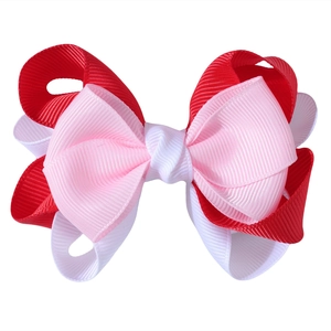 Detail of multi-layered red and pink grosgrain ribbon bow with fine fabric texture