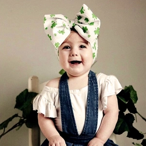 Détail d'un bandeau bébé avec trèfles verts et grand nœud pour la Saint-Patrick