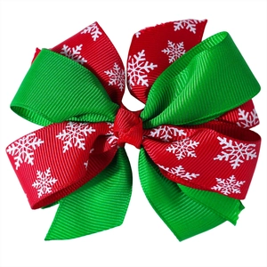 Detail of red and green Christmas hair bow with snowflake patterns and ribbed texture ribbon