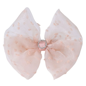 Close-up of pink mesh hair bow featuring flocked polka dots and a sparkling crystal center