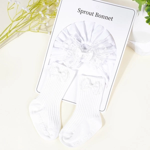 Detail view of white cotton sprout bonnet and knitted socks with lace ribbon bows