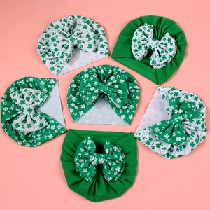 Vue détaillée de 6 bandeaux bébé avec nœuds et motifs trèfles verts de fête