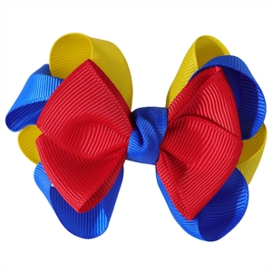 Detailed macro view of the layered red yellow and blue grosgrain ribbon bow accessory