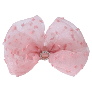 Close-up of pink tulle bow hair clip with swiss dots and sparkling rhinestone center
